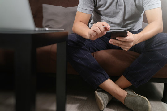 hipster hand using digital tablet docking keyboard and smart phone for mobile payments online business,omni channel,sitting on sofa in living room