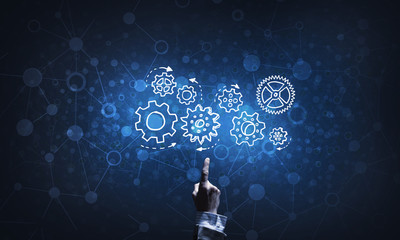 Glowing cogwheel mechanism icon on dark background as symbol of teamwork