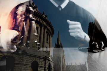 double exposure of justice and law concept.Male judge in a courtroom with the gavel,working with digital tablet computer on wood table,London architecture city
