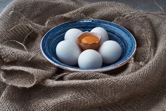 fresh eggs collected in the plate for cooking on the fabric.