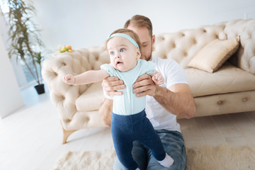 Curious kid in the arms of the father