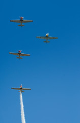 Vintage planes in formation with smoke trails