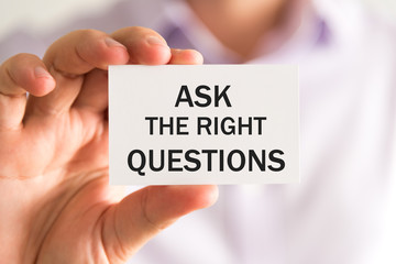 Businessman holding ASK THE RIGHT QUESTIONS card