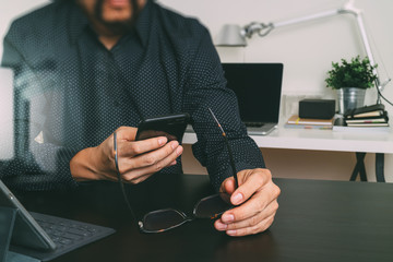 businessman,designer hand using smart phone,laptop,eyeglasses,online banking payment communication network technology 4.0,internet wireless application,modern office,filter effect