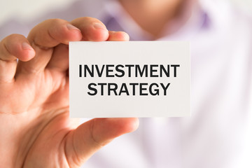 Businessman holding INVESTMENT STRATEGY card