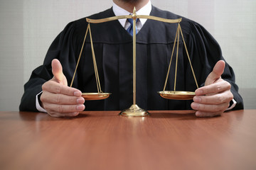  justice and law concept.Male judge in a courtroom with the balance scale on wood table