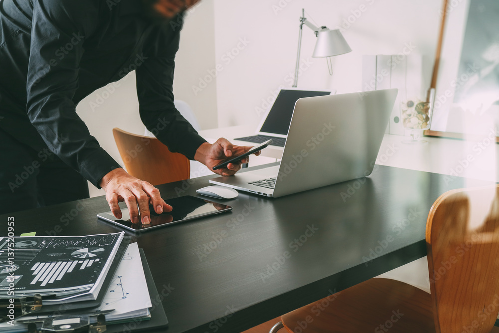 Poster businessman or Designer using smart phone with latop and digital tablet computer and document on desk in modern office