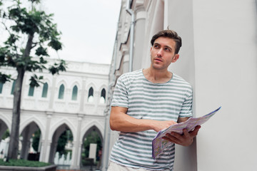 Fototapeta premium Young male traveler looking for the way with map