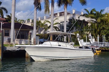White sport fishing boat docked at an exclusive gated island community in Miami Beach,Florida.