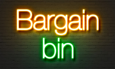 Bargain bin neon sign on brick wall background.