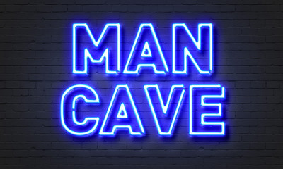 Man cave neon sign on brick wall background.