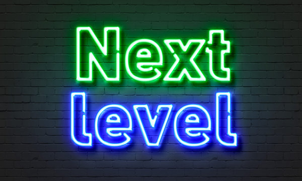 Next Level Neon Sign On Brick Wall Background.