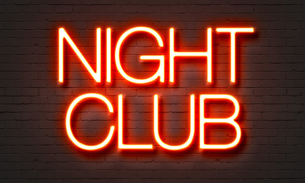 Night club neon sign on brick wall background.
