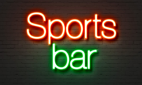 Sports bar neon sign on brick wall background.