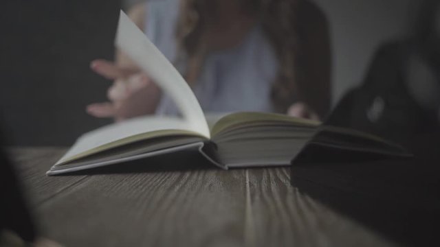 Girl leafing through a book closeup.