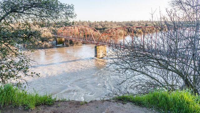 View of the red bridge, Fair Oaks, from the bluffs, with American River in flood