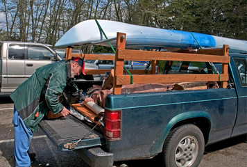 Middle Aged Man Preparing Truck for Camping and Kayak Trip © Valerie Garner