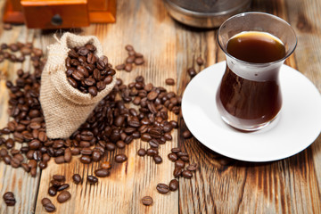 cup of coffee with grains on the wooden background