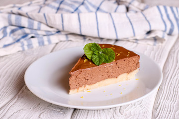 Chocolate cheesecake, decorated mint on a white plate, horizontal