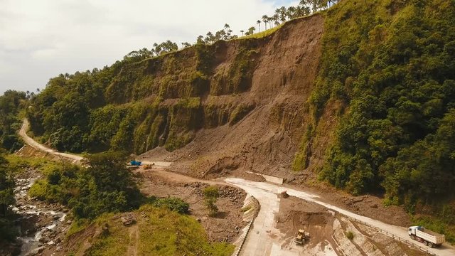 Landslides and rockfalls on the road in the mountains.Aerial view: mud and rocks blocking the road.Destroyed rural road landslide damaged in powerful flood. Collapsed on the mountain. Philippines