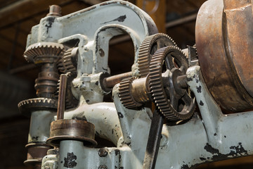 Closeup view of beautiful detailed old vintage machine tool gears and other parts on dark background 