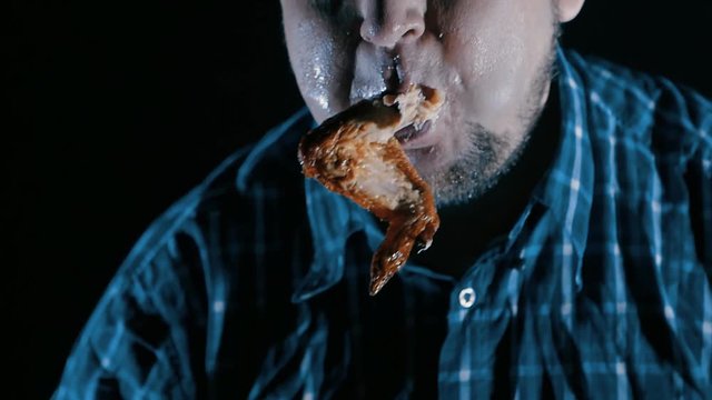 brutal man eating meat with blood slow-motion. concept of gluttony