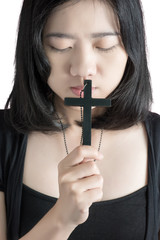 Obraz premium Beautiful asia woman with hopeful holding christian symbol of crucifix praying to God isolated on white background. Clipping path on white background.