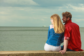 Couple sitting hugged on sea shore
