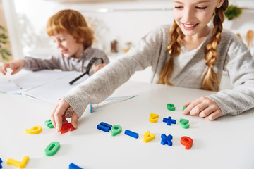 Adorable cheerful siblings doing math together