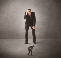 Obraz premium Big business man looking at small worker