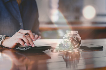 Close up of people hand work calculator and money,coins in finance banking and saving concept