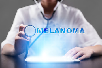 Medical doctor working with modern computer and pressing button melanoma. Medical concept.