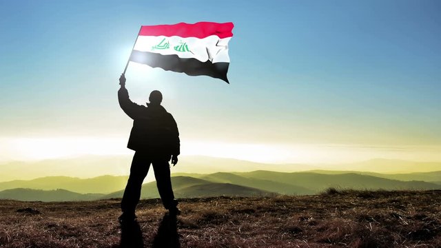 silhouette man waving Iraq flag