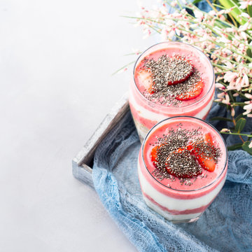 Yogurt strawberry fruit parfait festive romantic breakfast dessert with rolled oats and chia seeds on wooden tray textile. copy space