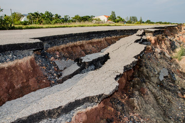 Side of the broken asphalt road collapsed and fallen