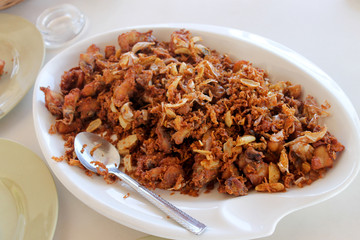 Fried chicken in pieces with garlic and onions