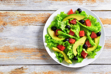 salad of  lettuce, avocado, chunks of salted salmon