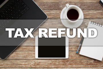 Tablet on desktop with tax refund text.