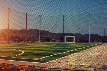 Artificial turf football field with vintage color filter and sunlight 