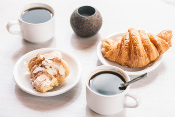 Breakfastat on White Table with Cups of coffee and croissants