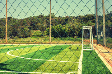 Artificial turf football field with vintage color filter and sunlight 