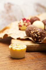 Selection of delicious chocolates on a rustic background