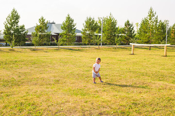 Naklejka na ściany i meble happy child boy with on meadow in summer in nature.