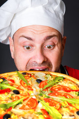 Portrait of happy attractive cook with a pizza