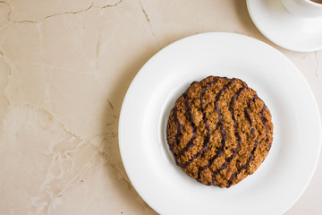 Oatmeal cookies with chocolate on a white plate. Tasty dessert.