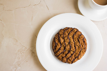 Oatmeal cookies with chocolate on a white plate. Tasty dessert.