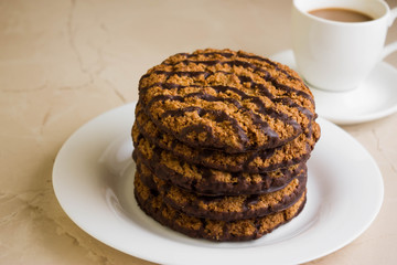 Oatmeal cookies with chocolate on a white plate. Tasty dessert.