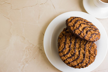 Oatmeal cookies with chocolate on a white plate. Tasty dessert.