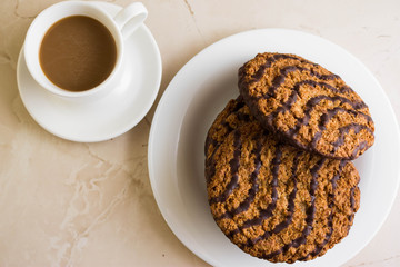 Oatmeal cookies with chocolate on a white plate. Tasty dessert.