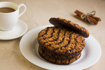 Oatmeal cookies with chocolate on a white plate. Tasty dessert.